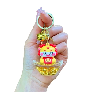 Cute golden dragon keychain with red festive outfit and liquid ingot base with gold beads