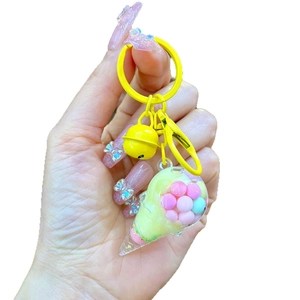 Cute ice cream keychain with yellow bell and colorful macaron balls in transparent cone