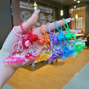 Close-up of liquid glitter ice cream keychains in six vibrant colors held by hand