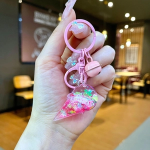 Detailed view of pink ice cream keychain with glitter star filling and metal bell