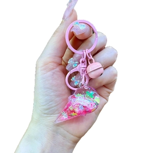 Pink ice cream keychain with colorful glitter and stars in a transparent cone charm