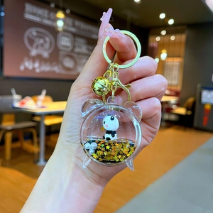Detailed close-up of a panda panda keychain in a clock-shaped bottle with floating glitter