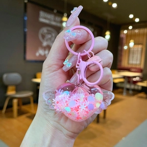Pink heart-shaped liquid wings keychain with floating glitter and cute pastel sequins