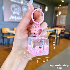Gros plan du porte-clés cochon rose avec sable mouvant liquide et paillettes cube