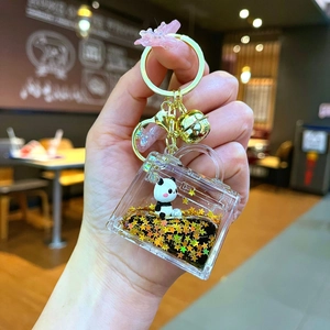 Detail of mini handbag keychain with panda figurine and gold stars in liquid acrylic