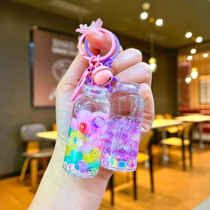 Luminous drifting bottle keychains with colorful liquid sand and pink bells on bag hooks