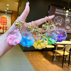 Macro shot of liquid quicksand seashell keychains with glitter and sea stars in five colors