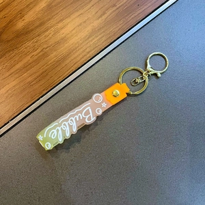 Detail of colorful gradient silicone strap with Bubble lettering and gold key ring