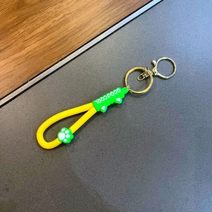 Détail du porte-clés patte de chat en silicone jaune et vert avec fermoir doré en métal