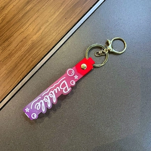 Detail of purple gradient silicone wristlet strap with Bubble lettering and gold hardware