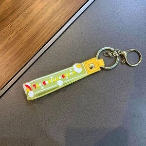 Detail of yellow silicone Sunshine Unicorn keychain strap with rainbow and cloud patterns