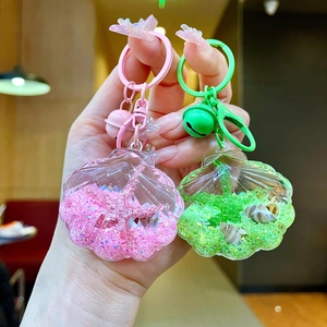 Detail of pink and green ocean shells keychains with liquid glitter and sea charms