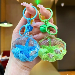 Detail of acrylic ocean shell keychains with blue and green liquid sand and starfish