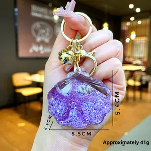 Detailed size view of a purple acrylic shell keychain with starfish glitter and liquid sand