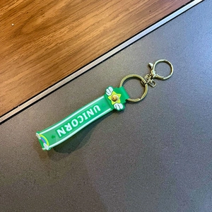Dettaglio del cordino in silicone verde con testo UNICORN bianco e chiusura dorata