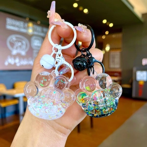 Detail of colorful quicksand cat paw keychains with small bells and sequins