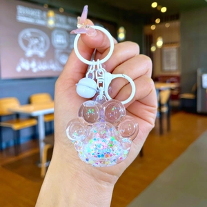 Macro view of cute cat paw acrylic keychain with colorful star sequins and fine glitter