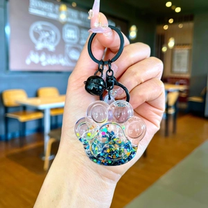 Close-up of cat paw keychain with blue star glitter inside being held in hand