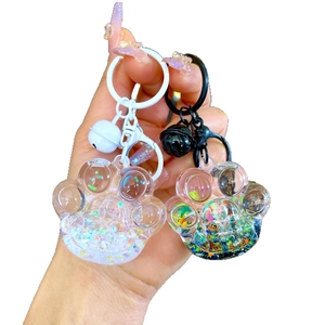 Cute resin cat paw keychains with colorful glitter and bells in black and white styles