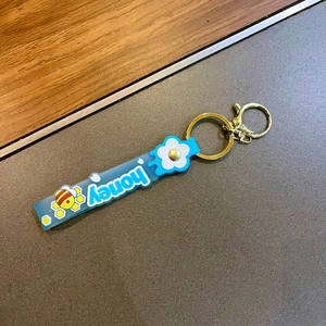 Blue silicone honey keychain with white flowers and a golden metal lobster clasp
