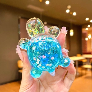 Handheld liquid turtle variant with blue glitter and cherry blossom sequins inside