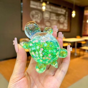 Green turtle figurine with sparkling sequins and colorful floral glitters