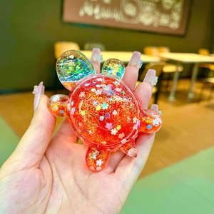 Creative red turtle keychain with colorful glitter and flowing liquid inside