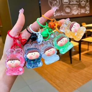 Detail view of five colorful acrylic liquid sand keychains with cartoon doll faces