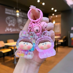 Cute cartoon resin doll keychain set with pink liquid glitter and bells on hand