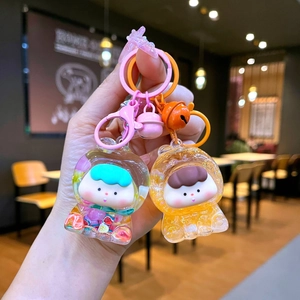 Détail de deux porte-clés mignons en acrylique avec tranches de fruits colorées et cloches