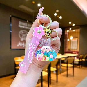 Glow-in-the-dark Sakura rabbit liquid sand keychain with pink strap and golden bell