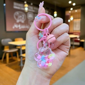 Vue détaillée du porte-clés patte de chat rose avec paillettes et petit grelot