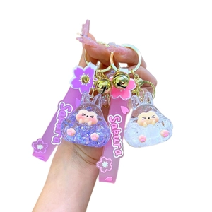 Pair of creative acrylic bunny liquid sand keychains with pink sakura charms and bells