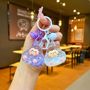 Close-up of cute cartoon resin keychains with glitter liquid and colorful bells