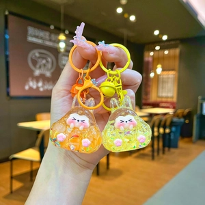 Close-up of liquid rabbit keychains with colorful flowing sand and metal bell details
