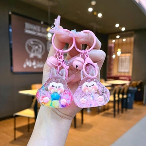Detail of pink rabbit oil-filled keychain with glitters, colorful balls and small bells