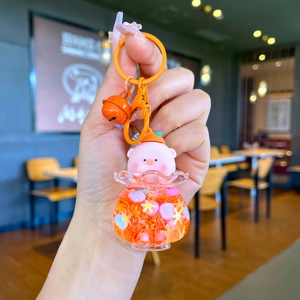Luminous floating pig keychain with orange liquid, pink mascot, and metal bell charm