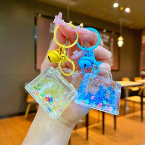 Close-up of creative liquid glitter handbag keychain charms with colorful sequins and bells