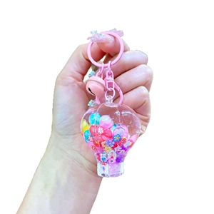 Pink hot air balloon keychain with colorful flowers and small bell accessory