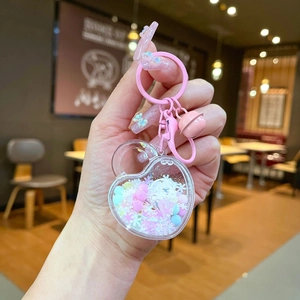 Luminous heart liquid keychain with pink glitter and snowflakes held in hand