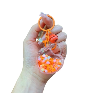 Luminous heart keychain with orange snowflakes and pink beads in acrylic oil liquid charm