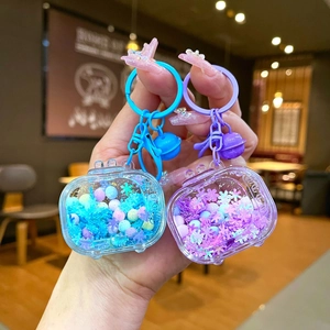 Detail of creative acrylic liquid sand TV keychains with colorful beads and bell charms