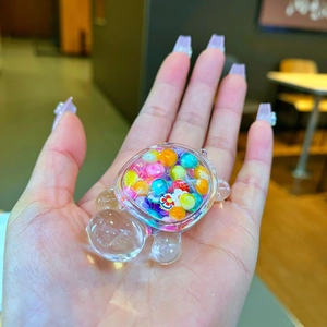 Close-up of resin turtle ornament filled with colorful beads and floral sequins