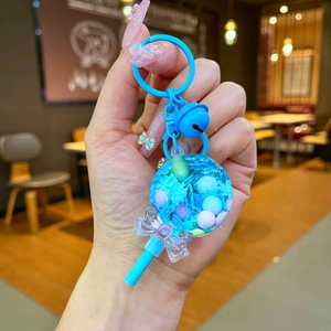 Porte-clés sucette avec perles colorées, paillettes et charm nœud papillon bleu