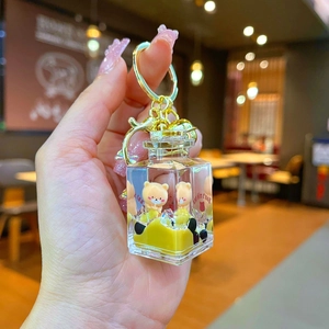 Detail of square bubble tea keychain with floating yellow bears in liquid sand