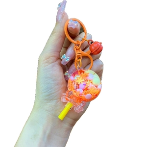 Lollipop keychain with orange sequins, colorful beads, pink bow, and red bell detail
