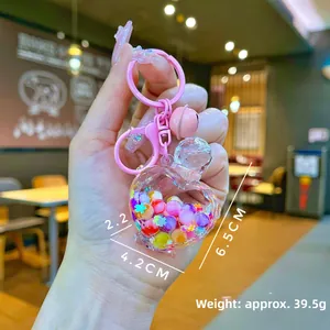 Detail shot of heart-shaped liquid quicksand keychain with colorful beads and stars