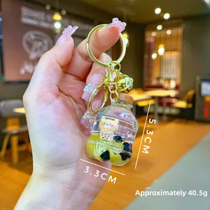 Detail of creative bubble tea keychain with floating bear and golden bell pendant