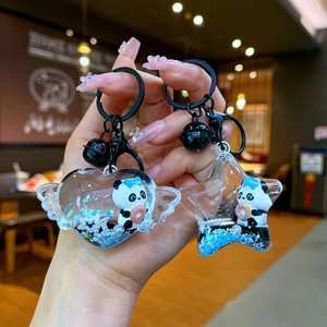 Détail des porte-clés panda avec sable mouvant bleu en formes d'étoile et cœur