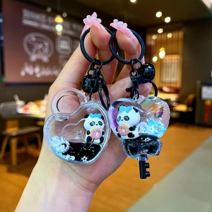 Détail du porte-clés liquide panda avec clip en forme de cœur et breloques de donuts